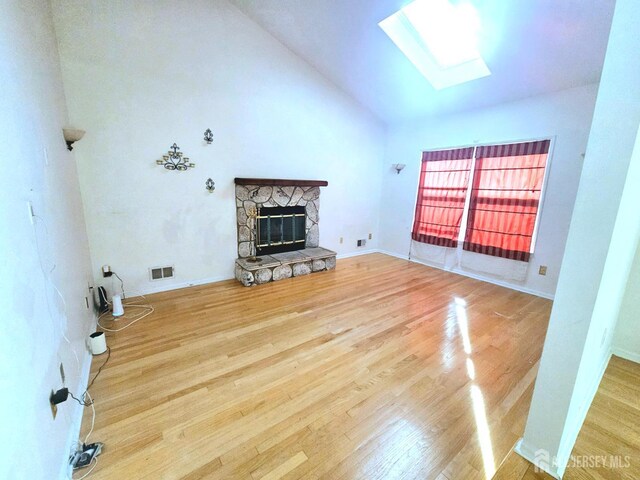 53 Perilli Dr, Hamilton, NJ 08610 - unfurnished living room featuring wood finished floors, a skylight, a fireplace, and high vaulted ceiling