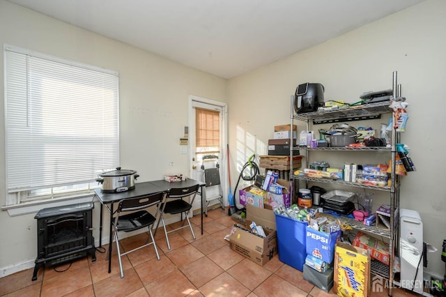 office space with a wood stove and tile patterned floors