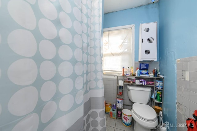 bathroom with toilet, tile patterned flooring, and tile walls