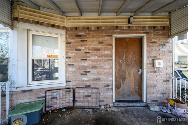 view of exterior entry with crawl space and brick siding