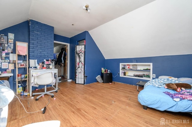 bedroom featuring lofted ceiling and wood finished floors