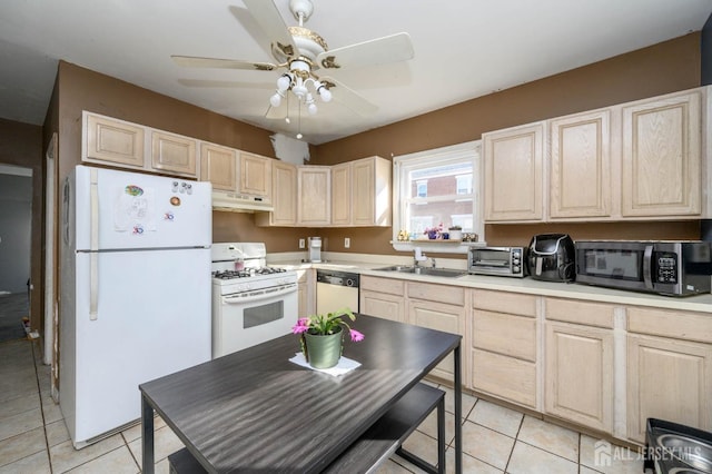 kitchen with under cabinet range hood, white appliances, a sink, light countertops, and light brown cabinetry