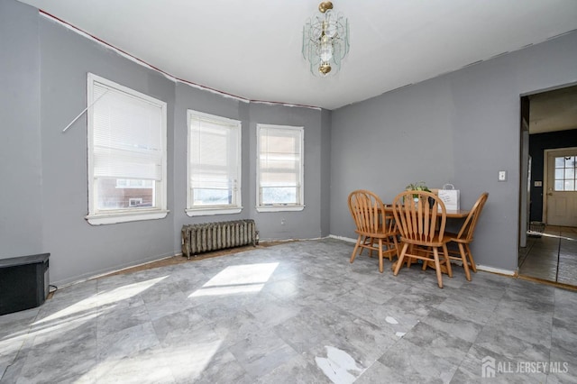 unfurnished dining area with radiator and baseboards