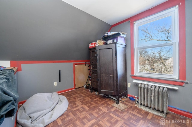 game room with baseboards, vaulted ceiling, and radiator heating unit