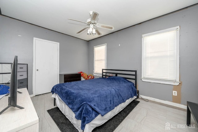 bedroom featuring a ceiling fan and baseboards