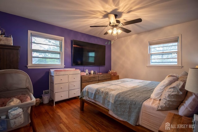 bedroom with multiple windows, wood finished floors, and ceiling fan