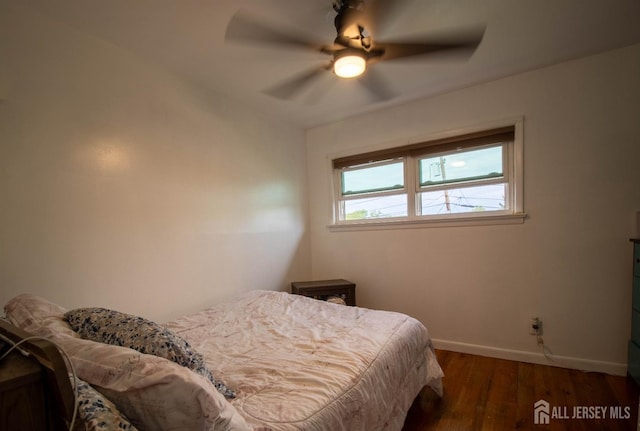 bedroom with baseboards, wood finished floors, and a ceiling fan