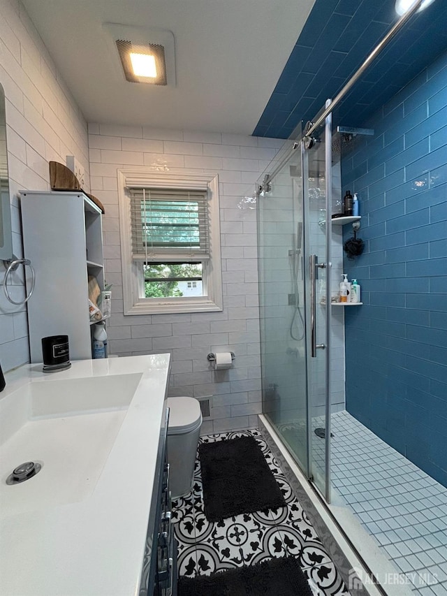 full bathroom with a shower stall, toilet, vanity, and tile patterned floors