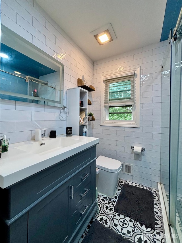 bathroom featuring tile walls, toilet, tiled shower, vanity, and decorative backsplash