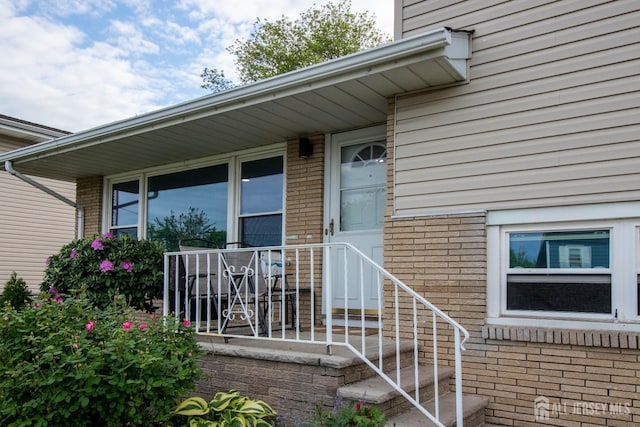 doorway to property featuring brick siding