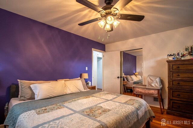 bedroom featuring wood finished floors, ceiling fan, and a closet