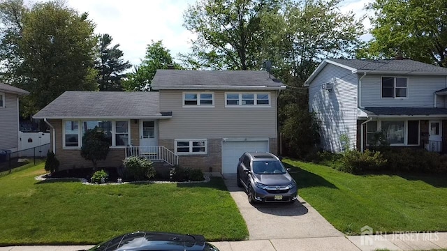 tri-level home with a garage, driveway, and brick siding