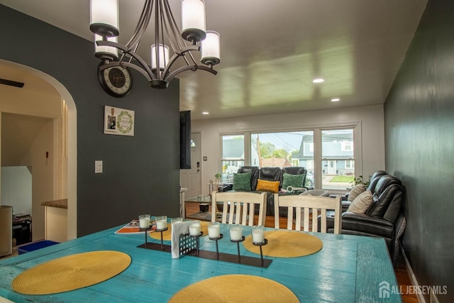 dining area with arched walkways, recessed lighting, and a chandelier