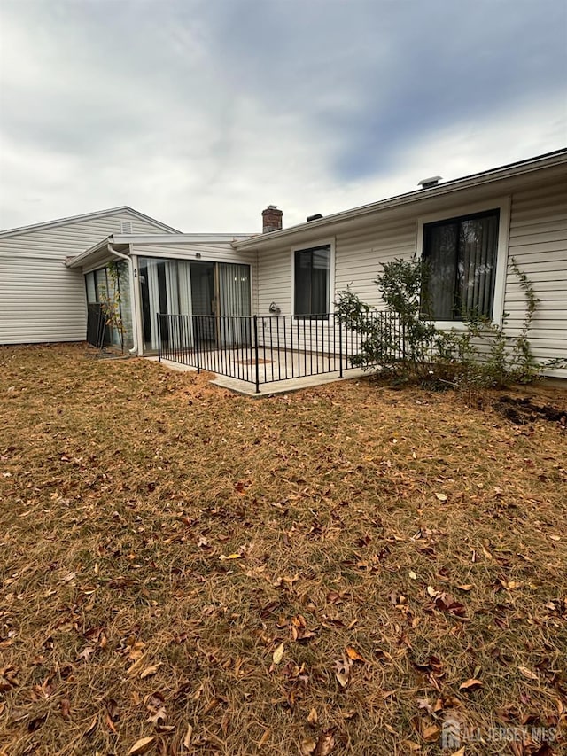 back of house featuring a sunroom and a patio