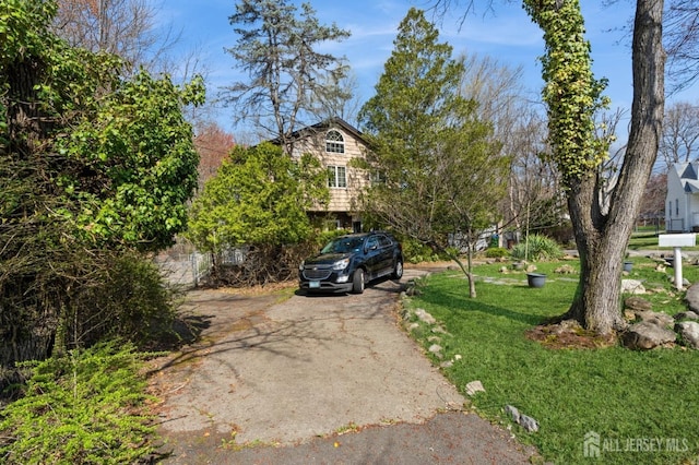 view of front of home featuring a front yard and aphalt driveway