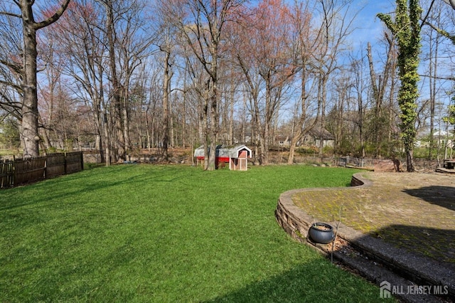 view of yard featuring fence and a storage unit