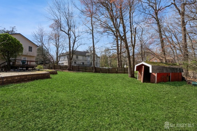 view of yard with an outbuilding, a shed, fence private yard, and a wooden deck