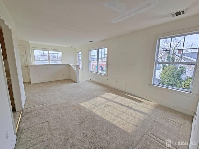 empty room with light carpet, baseboards, and visible vents