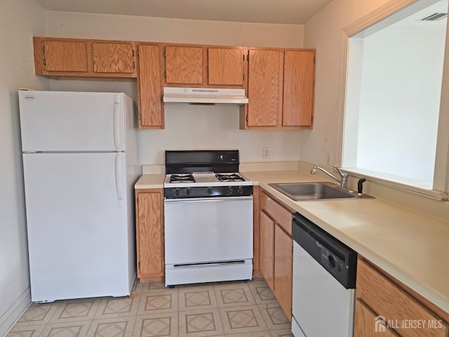 kitchen with light floors, light countertops, a sink, white appliances, and under cabinet range hood