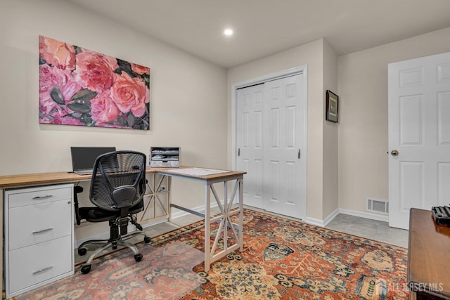 office featuring light tile patterned floors, visible vents, and baseboards