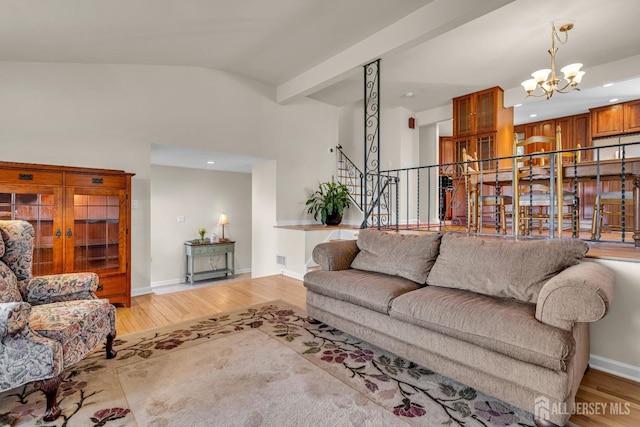 living room featuring light wood finished floors, stairway, a chandelier, and baseboards