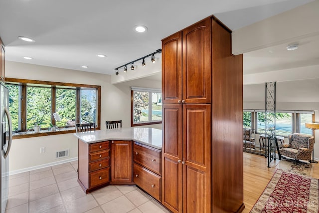 kitchen featuring a peninsula, recessed lighting, a healthy amount of sunlight, and visible vents