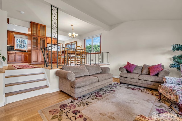 living room featuring stairway, baseboards, an inviting chandelier, light wood-style floors, and beamed ceiling