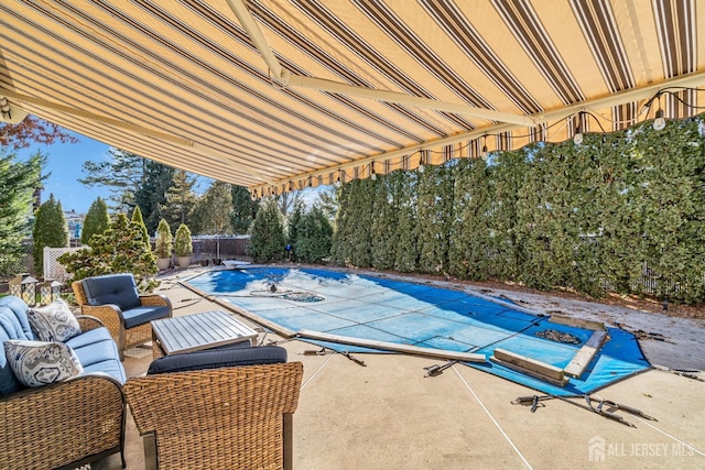 view of pool with a diving board, a covered pool, a fenced backyard, and a patio area