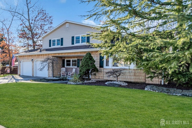 view of front of property featuring an attached garage, concrete driveway, and a front lawn