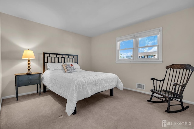 carpeted bedroom featuring visible vents and baseboards