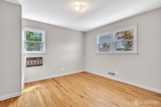 unfurnished room with visible vents, baseboards, and wood finished floors