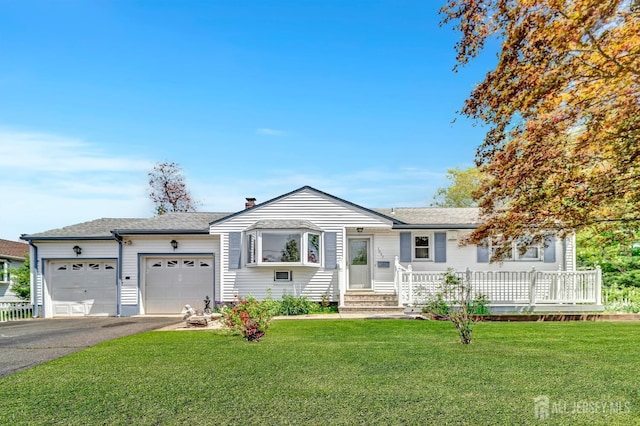 single story home featuring aphalt driveway, a shingled roof, a front yard, and a garage