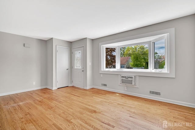 interior space featuring an AC wall unit, visible vents, and light wood finished floors