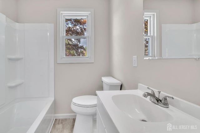 full bathroom featuring toilet, baseboards, plenty of natural light, and vanity