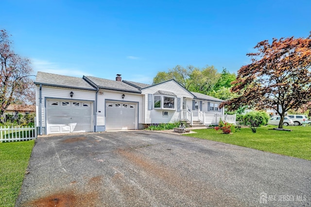 single story home with a garage, a front lawn, fence, a chimney, and driveway
