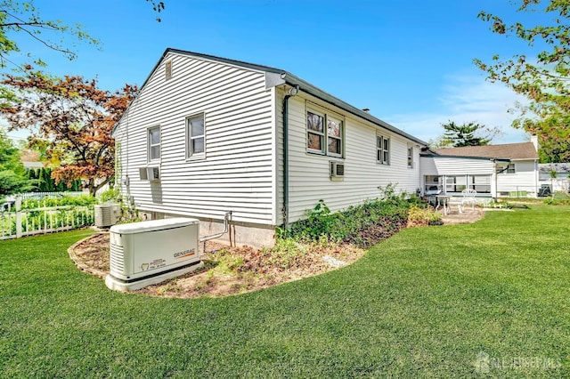 view of side of home featuring fence, central AC unit, and a yard