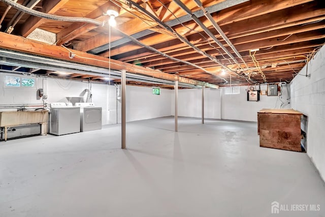 basement with separate washer and dryer, concrete block wall, a sink, and electric panel