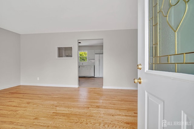 unfurnished room with baseboards and wood finished floors