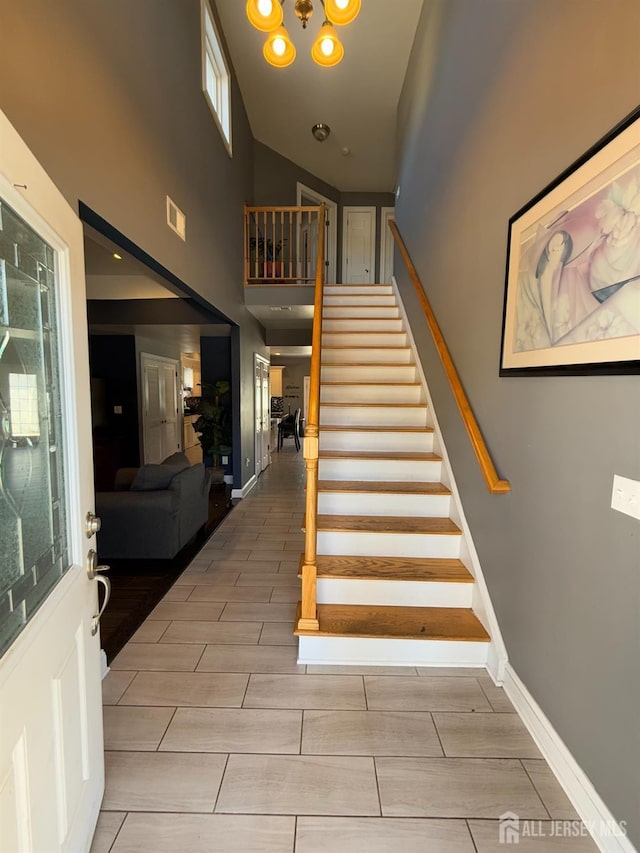 staircase featuring a towering ceiling