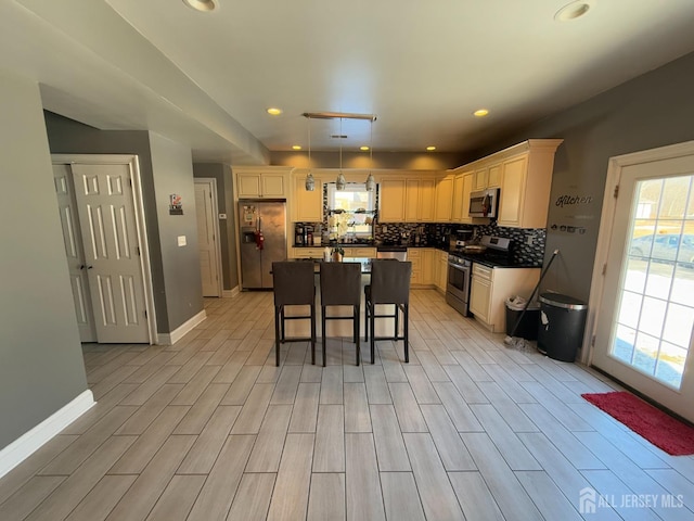 kitchen with a breakfast bar, backsplash, hanging light fixtures, a center island, and stainless steel appliances