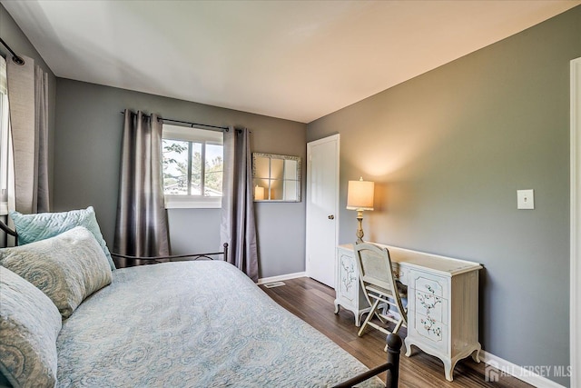 bedroom with baseboards and wood finished floors