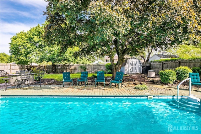 view of pool featuring a storage unit, a fenced backyard, an outdoor structure, and a patio area