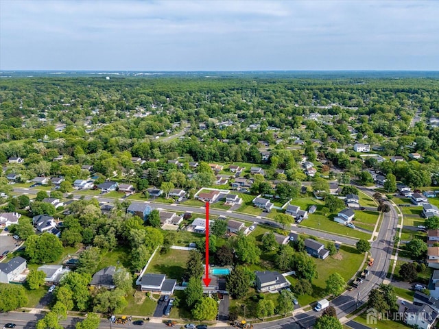 aerial view of property and surrounding area with a heavily wooded area