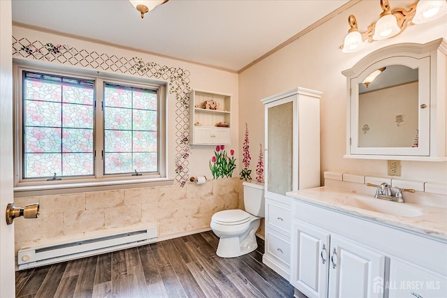 bathroom featuring a baseboard heating unit, ornamental molding, healthy amount of natural light, toilet, and vanity
