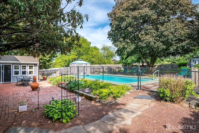 view of pool with a fenced backyard, a patio area, and an outdoor structure