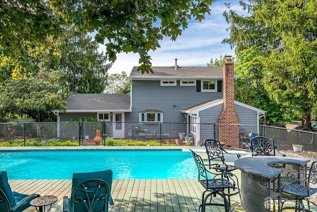 view of swimming pool with fence and a deck