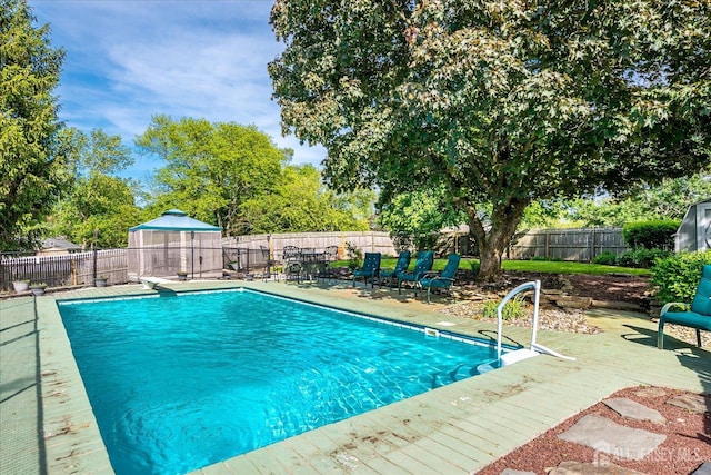 view of pool with a fenced backyard and a deck