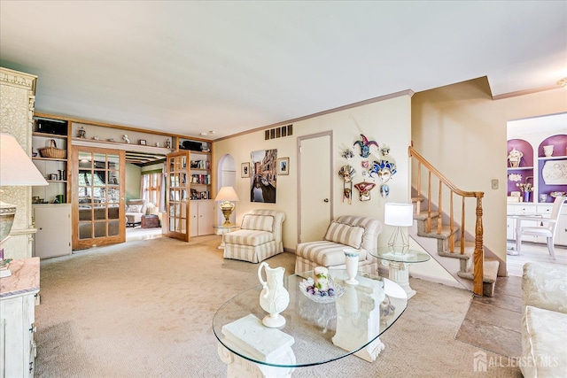 living area featuring carpet flooring, stairs, and ornamental molding