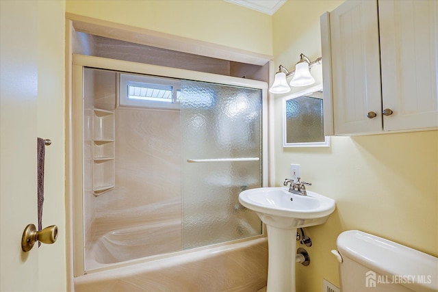 bathroom with toilet and bath / shower combo with glass door