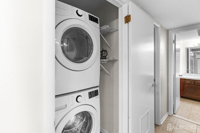 31 Hanover Sq, Middlesex, NJ 08846 - laundry area featuring stacked washer / dryer and light tile patterned floors